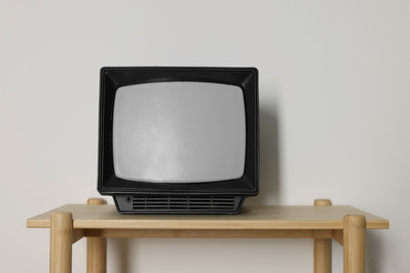 Retro tv set on wooden shelf against white wallの写真素材
