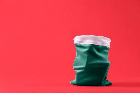 Green Santa Claus bag on red background, space for textの写真素材
