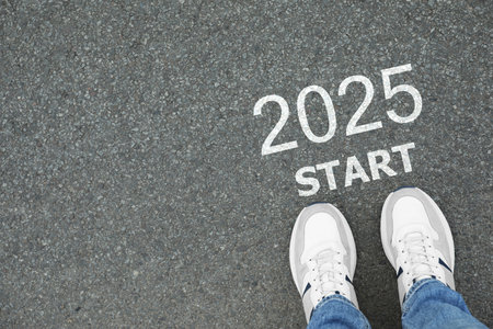 Man standing near sign 2025 Start on asphalt, top view. Concept of new year, fresh beginning