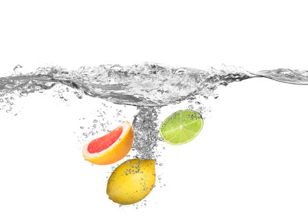 Citrus fruits falling into water on white backgroundの写真素材