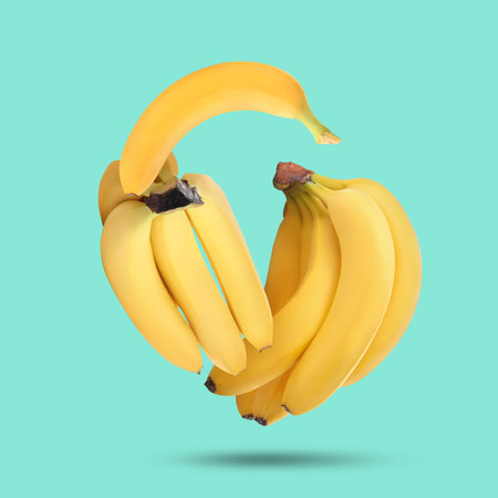 Many yellow bananas falling on turquoise backgroundの写真素材