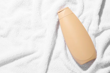 Shampoo in bottle on soft towel, top view. Space for textの写真素材