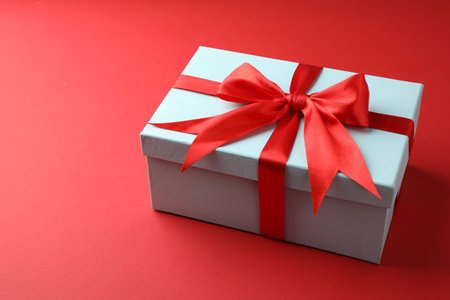 Gift box with bow on red backgroundの写真素材