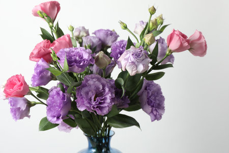 Beautiful eustoma flowers in vase on light background, closeupの写真素材