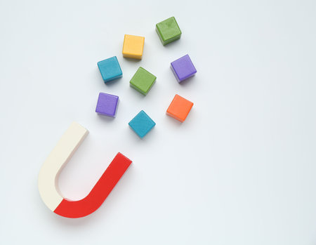 Magnet attracting colorful cubes on white background, flat layの写真素材