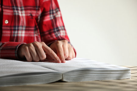 Blind woman reading book written in Braille at table, closeupの写真素材