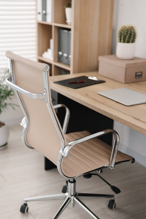 Beige leather chair, laptop and desk in office, above viewの写真素材