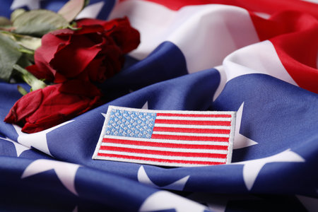 Veterans day. American army patch and rose flowers on USA flag, closeupの写真素材