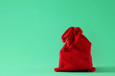 Red Santa Claus bag on green background, space for textの写真素材