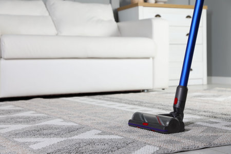 Cleaning with wireless vacuum cleaner at home, closeup. Space for textの写真素材