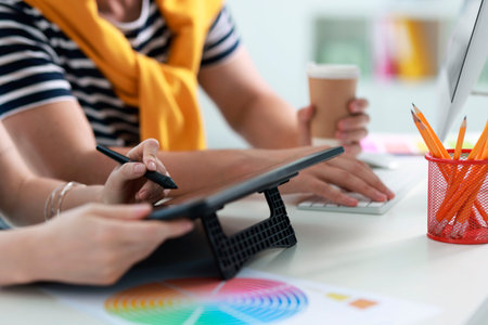 Designers with tablet working together at table in office, closeupの写真素材