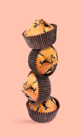 Stacked tasty blueberry muffins on pink beige backgroundの写真素材