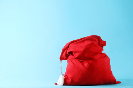 Red Santa Claus bag on light blue background, space for textの写真素材