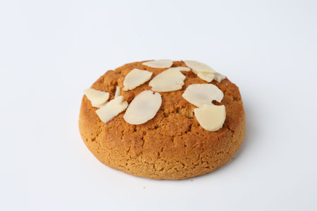 One tasty cookie with almond flakes on white backgroundの写真素材