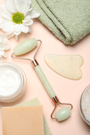 Flat lay composition with face roller and gua sha tool on beige backgroundの写真素材