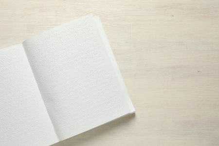 Book with Braille text on wooden table, top view. Space for textの写真素材