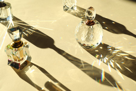 Many perfume bottles casting beautiful shadows on beige backgroundの写真素材