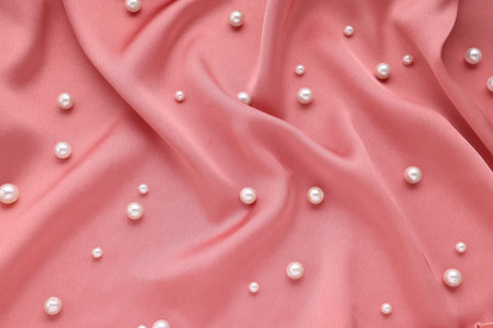 Many elegant pearls on pink fabric, top viewの写真素材