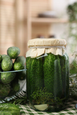 Pickled cucumbers in jar and fresh ones on table, closeupの写真素材