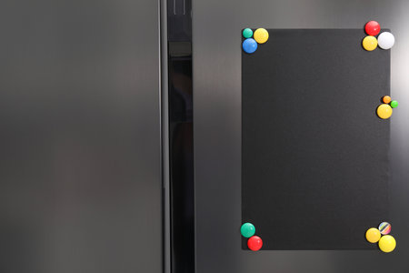Black note board with magnets on refrigeratorの写真素材