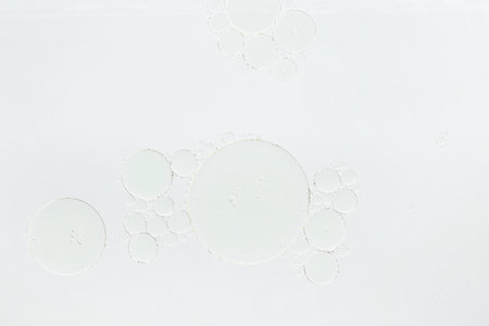 Essential oil bubbles on white background, macro view. Cosmetic product