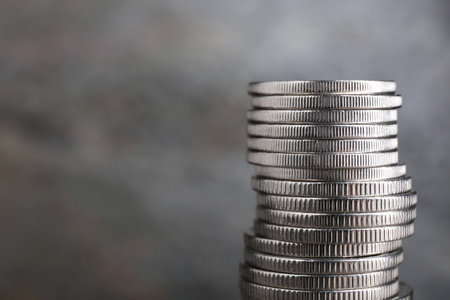 Stack of coins on blurred gray background, closeup with space for text. Salary conceptの写真素材