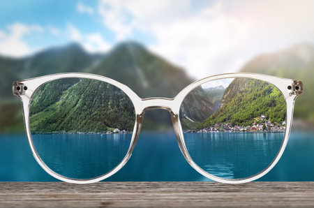 Glasses against beautiful landscape. View through lenses more clear.の写真素材