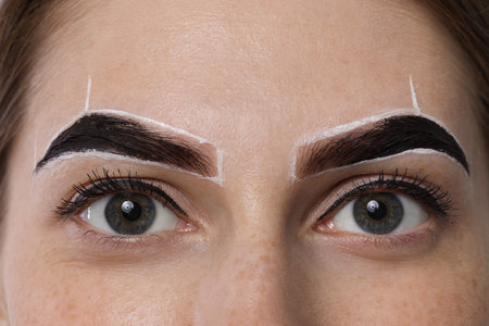 Young woman during henna eyebrows dyeing procedure, closeupの写真素材