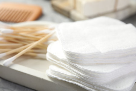 Clean cotton pads and swabs on gray table, closeupの写真素材