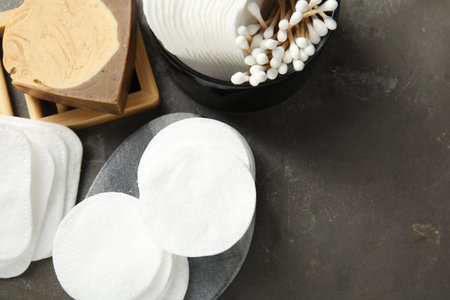 Many cotton pads and swabs on gray textured table, flat lay. Space for textの写真素材