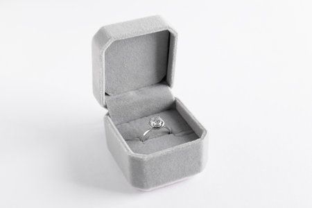 Beautiful ring with gemstone in box on white background