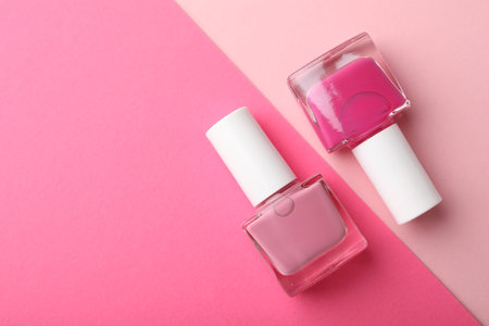 Nail polishes in bottles on color background, flat lay. Space for textの写真素材