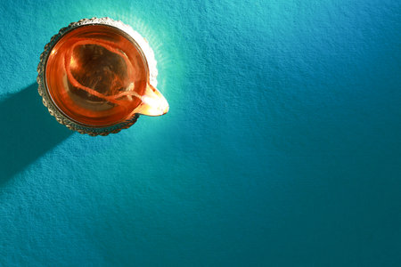 Diwali celebration. Diya lamp on teal background, top view. Space for textの写真素材