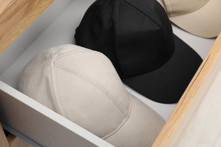 Stylish cap baseballs in chest of drawers. Mockup for designの写真素材