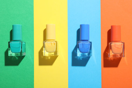 Nail polishes in bottles on color background, flat layの写真素材
