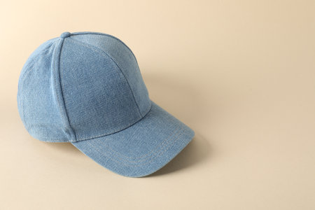 Stylish denim baseball cap on beige background. Mockup for design