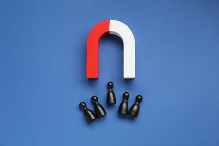Magnet attracting human figures on blue background, flat layの写真素材