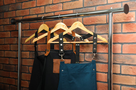 Many chef's aprons hanging on brick wallの写真素材
