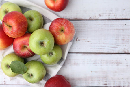 Different whole ripe apples on white wooden table, flat lay. Space for textの写真素材