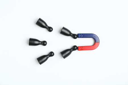 Magnet attracting human figures on white background, flat lay