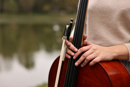 Young woman with cello in park, closeup.の写真素材