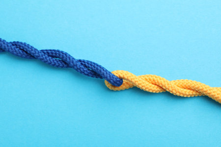 Colorful ropes tied together on light blue background, top view. Unity conceptの写真素材