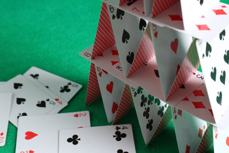 House of playing cards on green background, closeupの写真素材