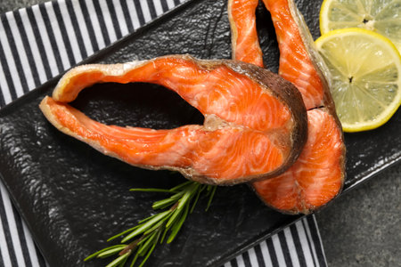 Tasty grilled salmon steaks, lemon and rosemary on table, top viewの写真素材