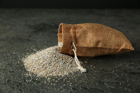 Sack with fresh rye bran on gray textured table, closeupの写真素材