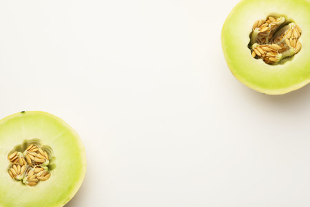 Halves of fresh ripe melon on white background, top view. Space for text