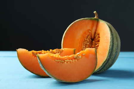 Cut ripe Cantaloupe melon on light blue wooden table, closeupの写真素材