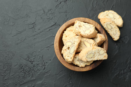 Traditional Italian almond biscuits (Cantucci) in bowl on black table, top view. Space for textの写真素材