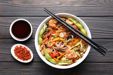Stir-fry noodles with sea food served on wooden table, flat layの写真素材