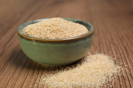 Oat bran in bowl on wooden table, closeupの写真素材
